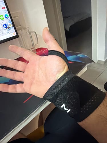 Recensore mostra il GripBand Polsino nero indossato al polso, con la mano aperta.