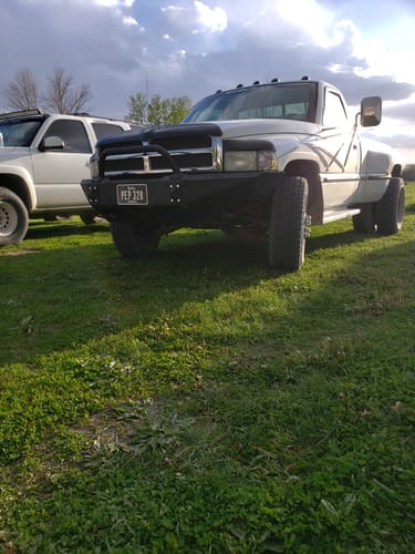 Customer's white Dodge Ram dually truck after installing the 3" front leveling lift kit, parked on grass.