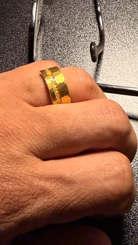 Customer showing the faceted gold Dominus ring with a central inlay on their hand.