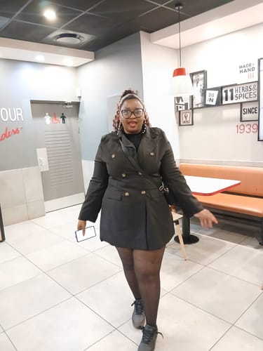 Reviewer styling the black Double-Breasted Blazer from the set as a dress indoors.