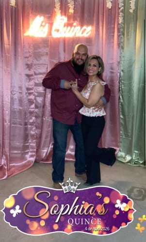 Customer wearing the floral Zala Corset Ruffle Top while posing with another person at a celebration.