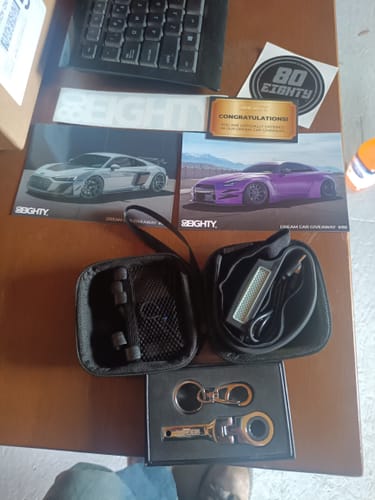 Customer's 80Eighty HeadLamp in its open case, laid out on a desk with other branded merchandise.