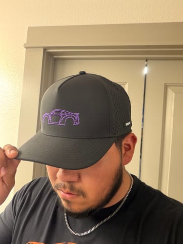 Customer wearing the dark gray DCG88 Hat, showing the purple car outline.