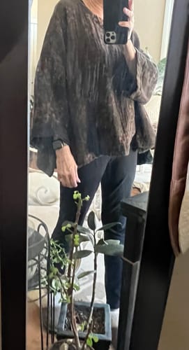 Reviewer taking a mirror selfie wearing the dark, loose-fitting Autumn Retro Flower Linen Blouse.