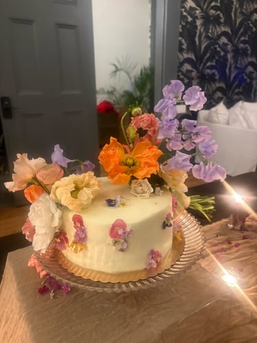 Customer's white frosted cake decorated with colorful BEGONIA - Freeze Dried Edible Flowers pressed on the side.