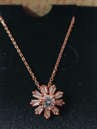 Customer's close-up photo of the Rose Gold Baguette Flower Pendant with its link chain on a black display card.