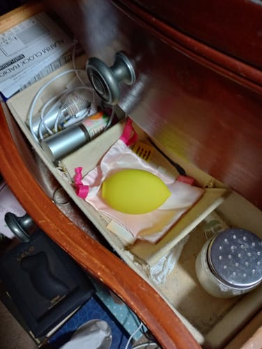 Reviewer's yellow Lem Clitoral Massager resting in an open bedside drawer.
