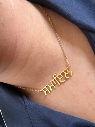 Reviewer wearing their Punjabi Name Necklace, showing the large size of the gold nameplate against their neck.
