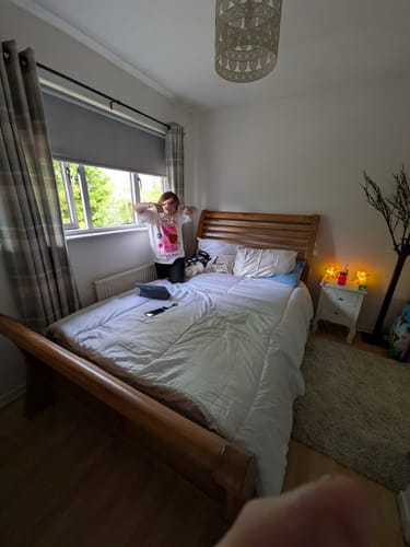 Reviewer's small Highland Cow LED Night Lights glowing on a bedside table in a bedroom.