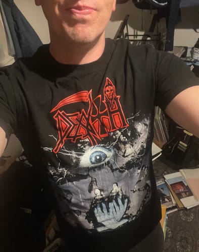 A customer wearing the black Death - Symbolic shortsleeve shirt, showing the fit and large graphic.