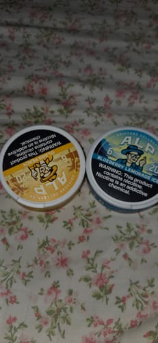 Customer's two tins of ALP Drifters, showing the Blueberry Lemonade Ice and another flavor, on a floral background.