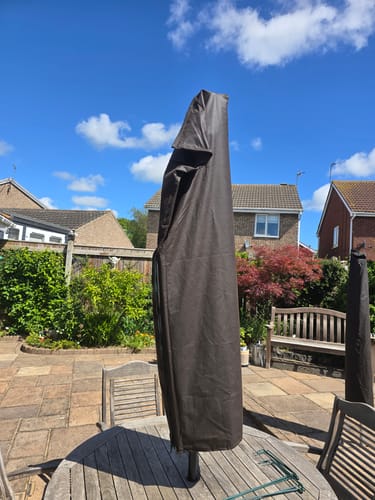 Customer's handmade parasol cover made from the dark waxed cotton fabric, shown on an outdoor table.