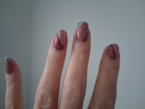 Nahaufnahme der Hand einer Kundin mit den 'It Girl Marble'-Nagelfolien in Marmoroptik.