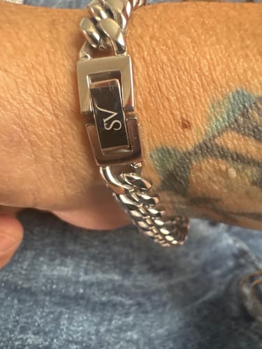 Un cliente muestra la Cadena Cuban Link 8mm en su muñeca, con un primer plano del broche plateado.