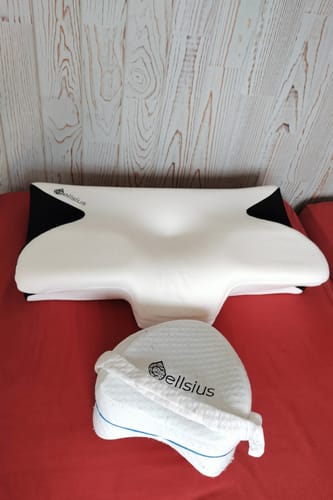 Photo d'un client montrant l'oreiller d'alignement cervical et le coussin pour les jambes sur une surface rouge.