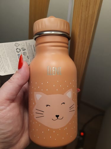 Ein Kunde hält die personalisierte Trixie-Edelstahl-Trinkflasche mit Katzenmotiv und dem Namen 'Elleni' in der Hand.
