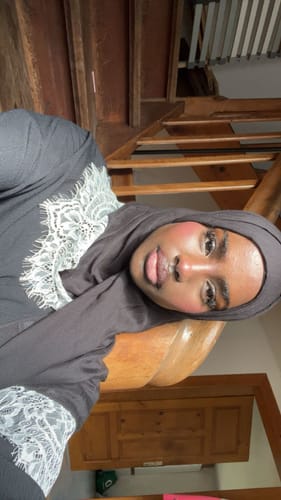 Reviewer wearing the black Midnight Lace Modal hijab, highlighting the elegant white lace trim.