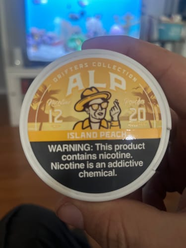 Customer holding a can of Drifters Island Peach Nicotine Pouches, showing the yellow label.