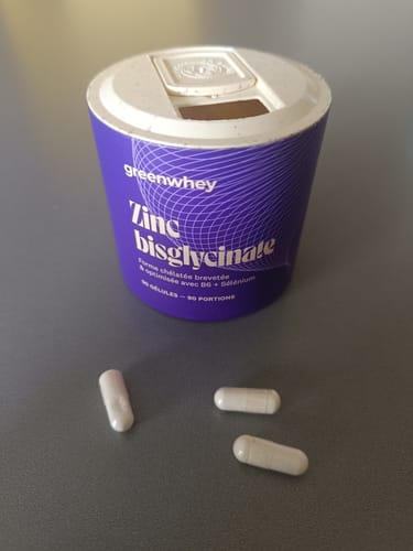Le pot violet de Zinc Bisglycinate d'un client, avec trois gélules blanches posées devant.