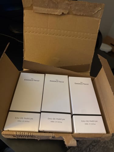 Customer's three white boxes of The Essence Vault perfume inside a cardboard shipping box.
