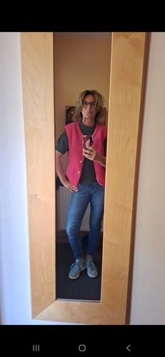 Rezensentin macht ein Spiegel-Selfie mit der pinken Teddy-Weste über einem T-Shirt.