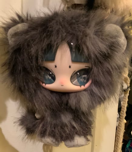 A customer's close-up of the grey INN'S Play Loud Series Plush, showing its fluffy fur and large, detailed blue eyes.