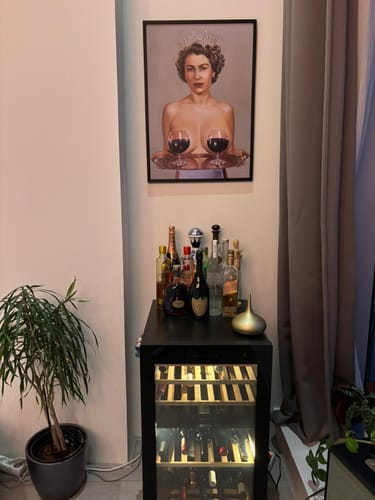 Customer's framed Majestic art print hanging on a wall above a small wine cooler and bar setup.