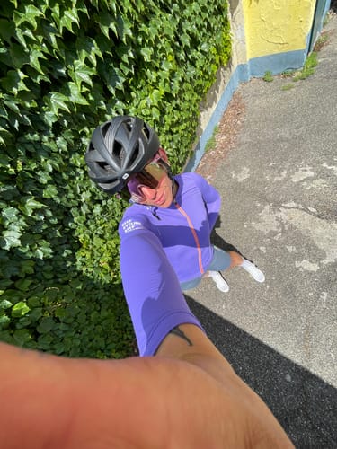 Reviewer taking an outdoor selfie in their purple long-sleeved cycling jersey and helmet.