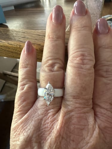 Customer's hand wearing the white silicone ring with a large marquise-cut stone.