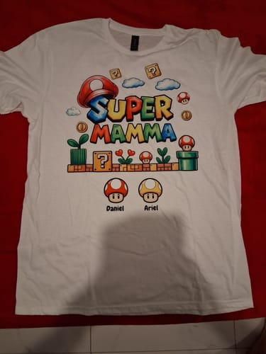 Rezensent zeigt das personalisierte weiße T-Shirt „Super Mamma“ mit den Namen Daniel und Ariel.