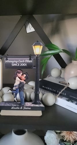 Reviewer's personalized wooden plaque on a shelf, showing a couple under a lamp post with custom names and text.