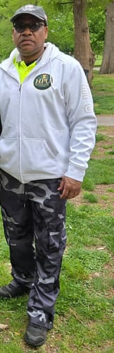 Customer standing outdoors in their custom white full-zip varsity hoodie.