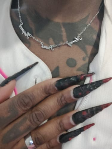 Close-up of a customer wearing the silver Personalized Name Necklace with three names.