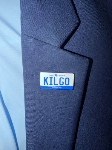 Customer's Michigan License Plate Enamel Pin, customized with 'KILGO', on a dark blue jacket lapel.