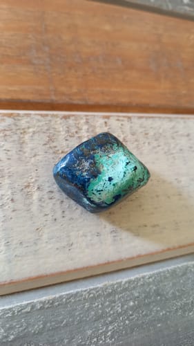 Photo d'un client d'une pierre Shattuckite roulée, montrant de belles couleurs bleues et vertes.