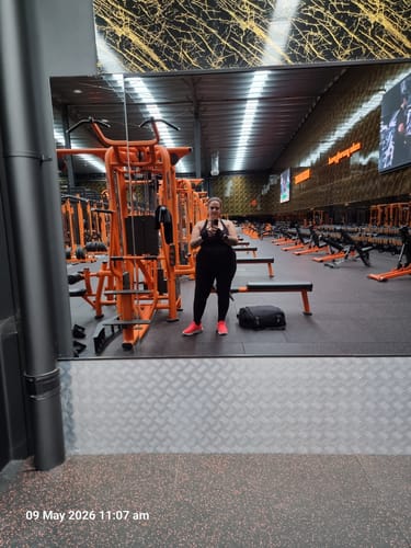 Reviewer taking a mirror selfie in a gym, wearing the full-length black Silix™ Sculpting Leggings.