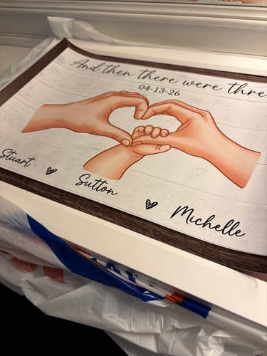 Customer's personalized poster for a family of three, showing hands making a heart. The skin tone appears somewhat orange.