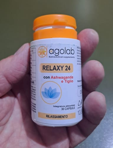 Recensore tiene in mano il flacone bianco dell'integratore Relaxy 24.