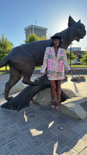 Customer wearing the Suiting Floral Jacquard Mini Skirt and matching blazer as a graduation outfit outdoors.