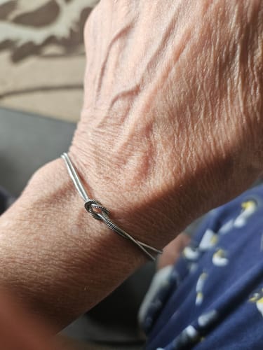 A reviewer's wrist wearing the Forever Knot Bracelet, showing how it fits loosely.