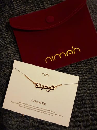 Customer's Urdu Name Necklace on its packaging card with its red velvet pouch.