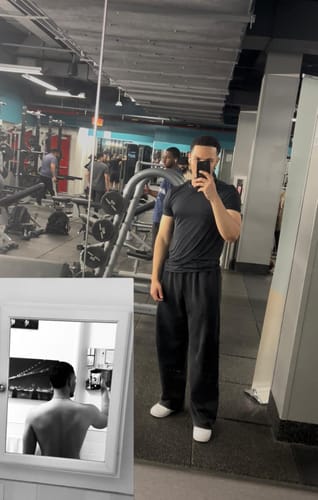 Reviewer in a gym wearing the black, baggy 2099 - Batman Stealth Sweats.