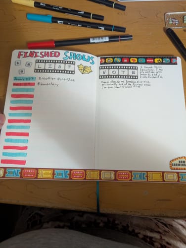 Reviewer's 'Finished Shows' list in their Movie Night journal, decorated with filmstrip stickers and ticket-themed washi tape.