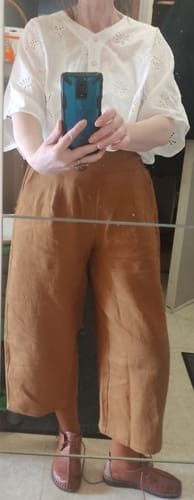 Cliente portant le Pantalon Briac ocre. La coupe large lui donne une longueur de pantacourt.