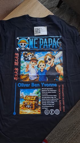 Kunde zeigt das personalisierte ONE PAPA T-Shirt mit einem farbenfrohen Anime-Druck.