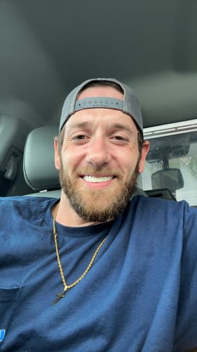 Customer smiling in a car, showing off their bright and perfect Pop On Veneers.