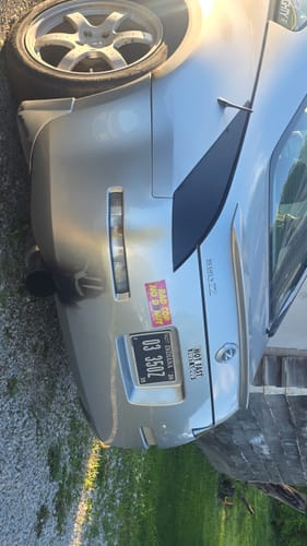 A customer's 'Bad Cop Slap Sticker' on the trunk of a silver Nissan Z sports car.