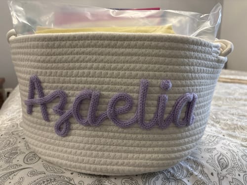 Customer's personalized woven basket with the name 'Azalia' written in purple yarn on the side.