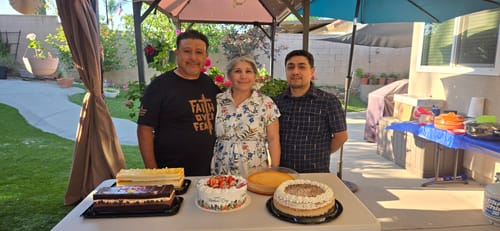 Customer wearing the black Faith Over Fear Tee while smiling with family at an outdoor gathering.