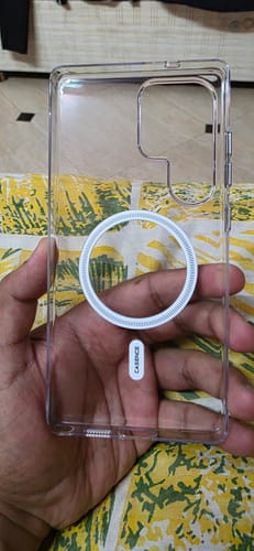 Customer holding the transparent Anti Yellow Magsafe Clear Case, showing the white magnetic ring and side buttons.